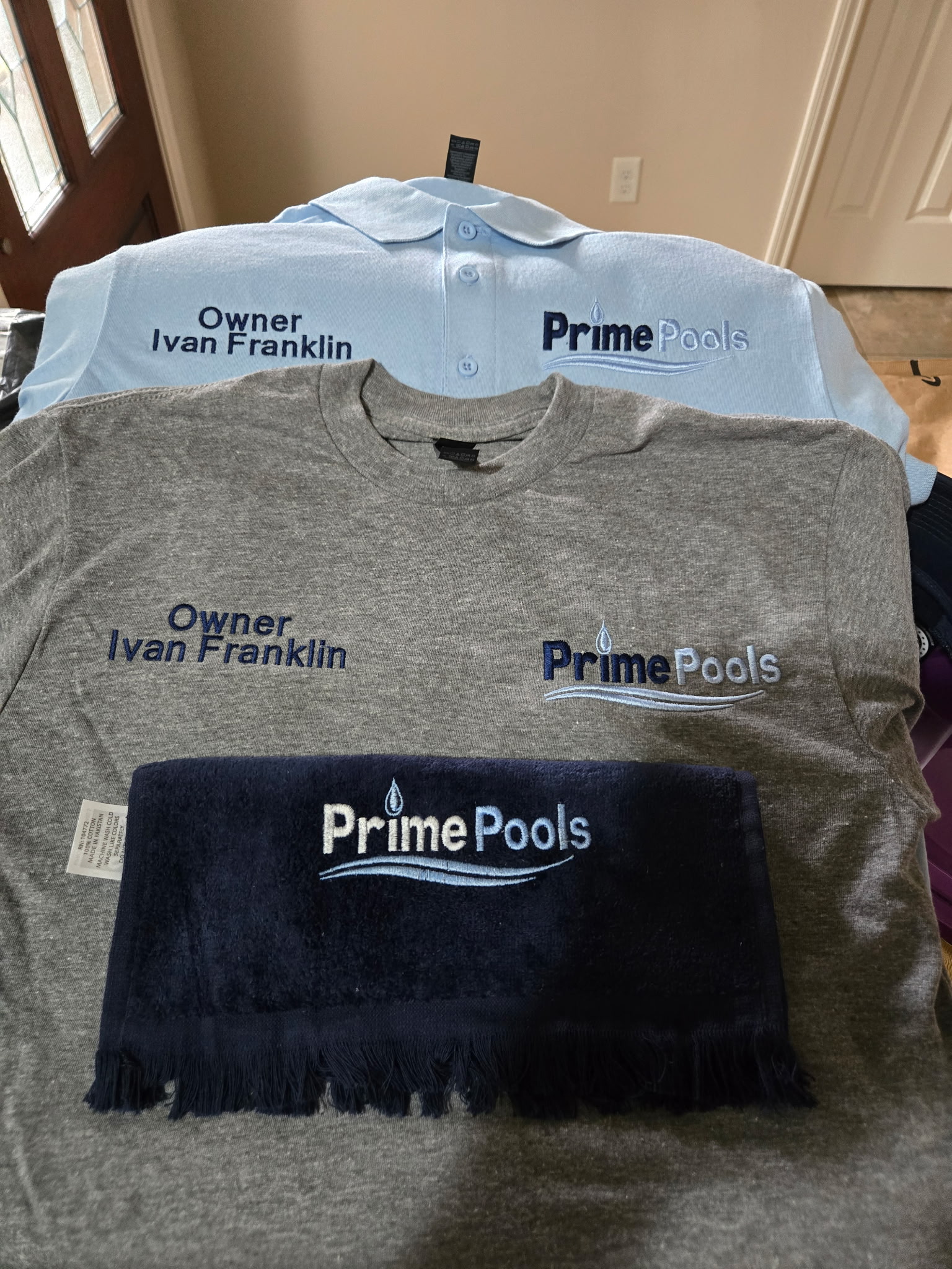 Prime Pools polo, t-shirt, and matching towel embroidered with the owner's name.
